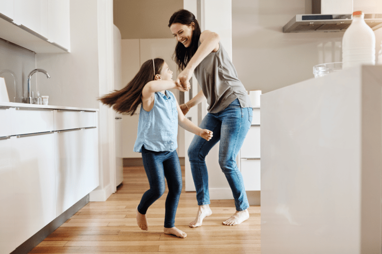 mother and daughter playing game in kitchen