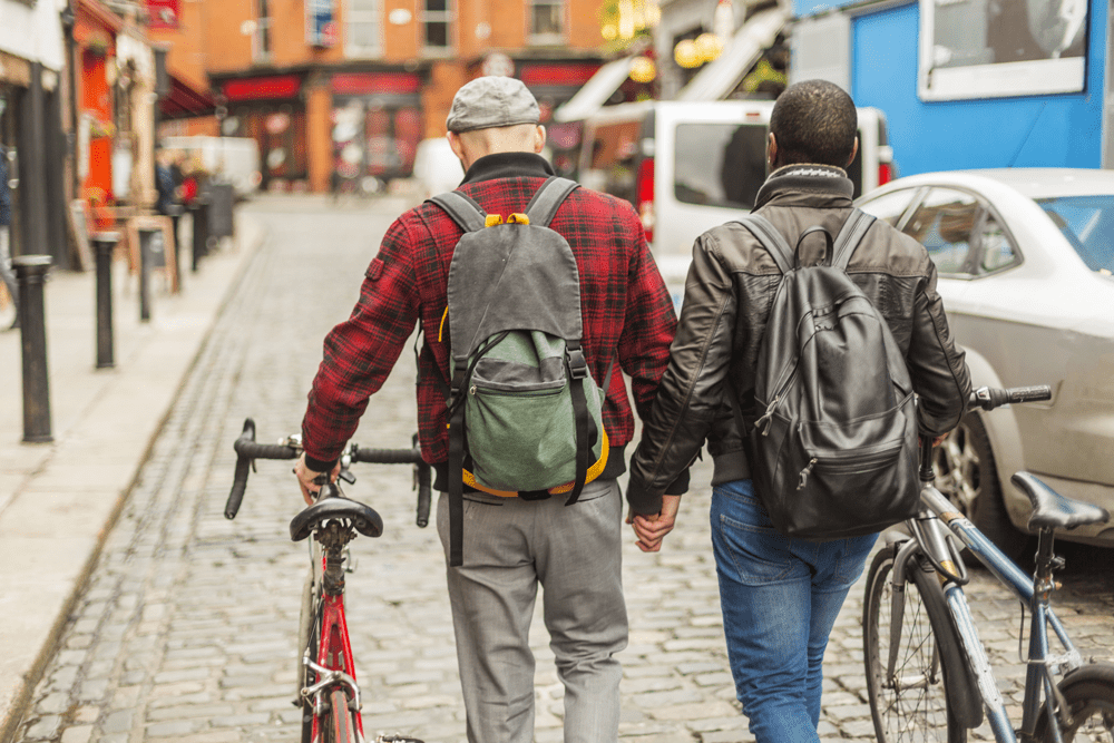 couple holding hands and moving their bikes