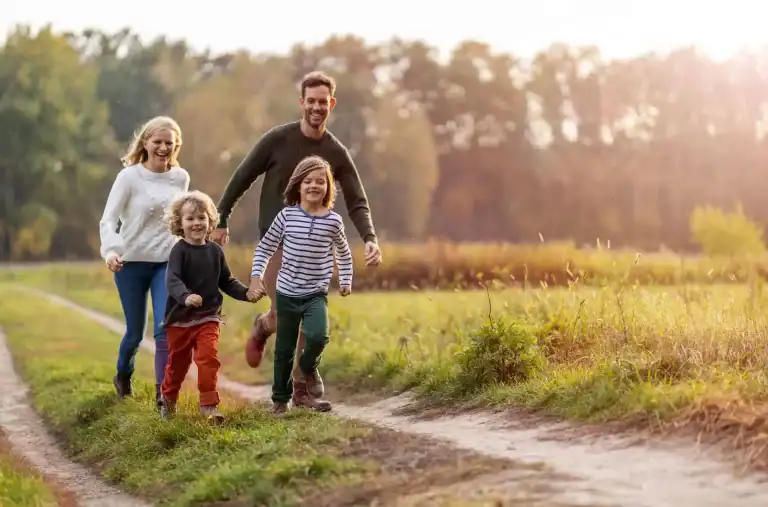 Family walking in a park, enjoying nature and outdoor exercise.