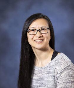 Friendly woman with glasses smiling, portrait shot for health and wellness professionals.