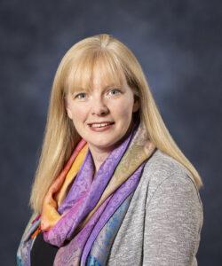 Relaxed woman with blonde hair and colorful scarf, wellness, holistic health, stress relief, therapy session.