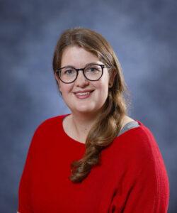 Warm red sweater woman with glasses for therapy and wellness.