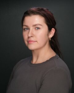 Calm woman with dark hair and grey top for mental wellness and holistic health.