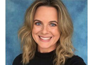 Therapist smiling with blue eyes and wavy blonde hair at Mind & Body Works.