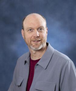 Professional man smiling, health and wellness expert at Mind & Body Works.