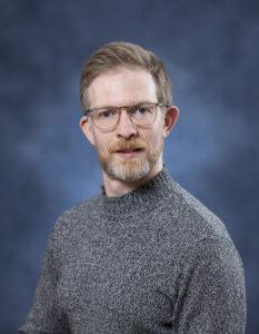 Professional man with glasses and beard, promoting mental health and well-being.