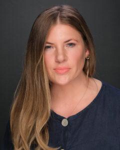Mind and body wellness therapist woman with long brown hair black background.