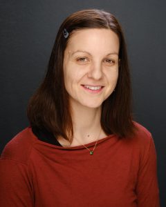 Friendly woman smiling, promoting holistic health and wellness services.