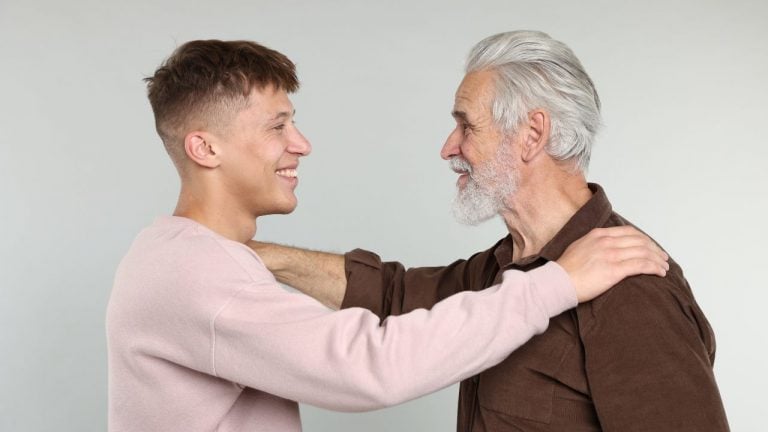 A father and son smiling and embracing, symbolising a strong bond and connection.