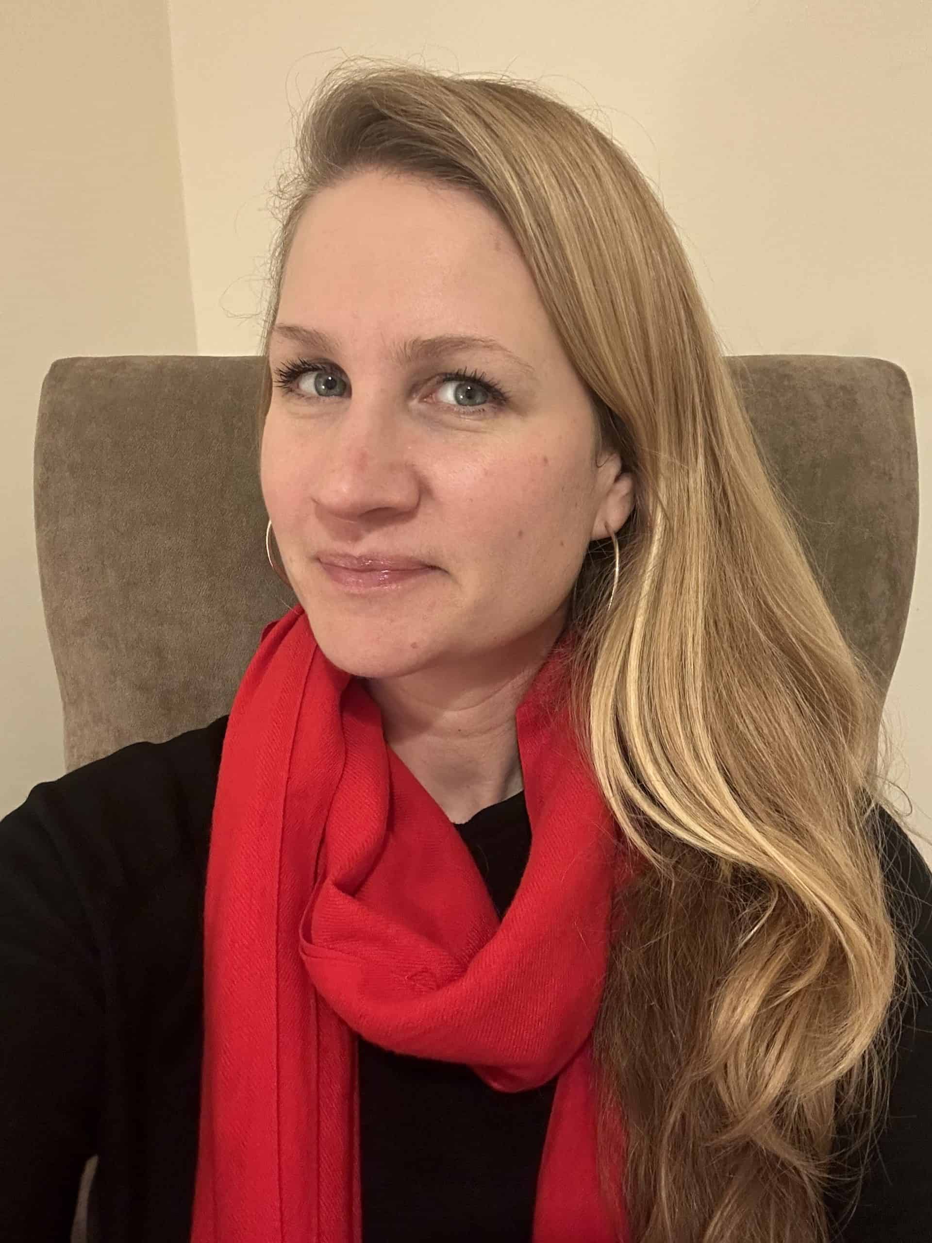 Relaxed woman with red scarf, promoting health and well-being.