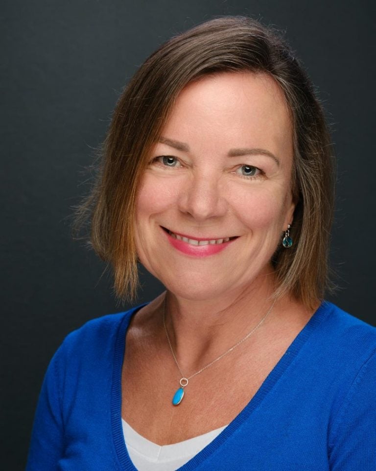 Professional woman smiling, promoting health and wellness services.