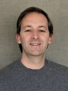 Relaxed man smiling, promoting wellness and mental health at Mind & Body Works.